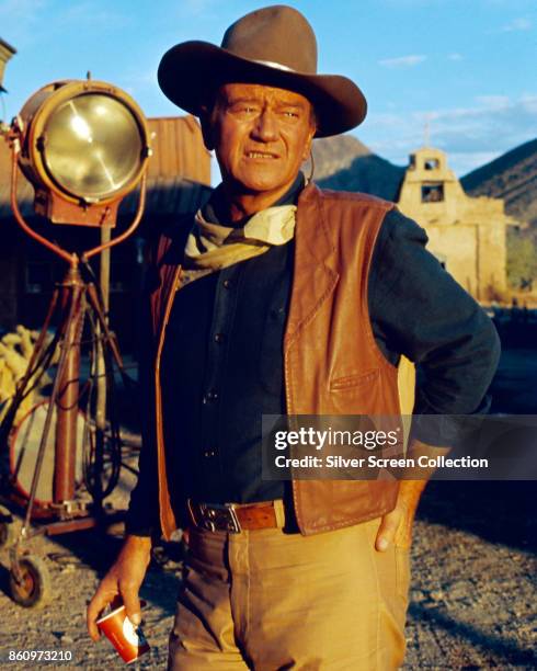 American actor John Wayne stands by a lighting rig on the set of 'El Dorado' , 1967.