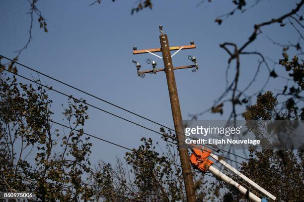 Workers work to repair power lines in the Coffey Park neighborhood following the damage caused by the Tubbs Fire on October 13, 2017 in Santa Rosa,...