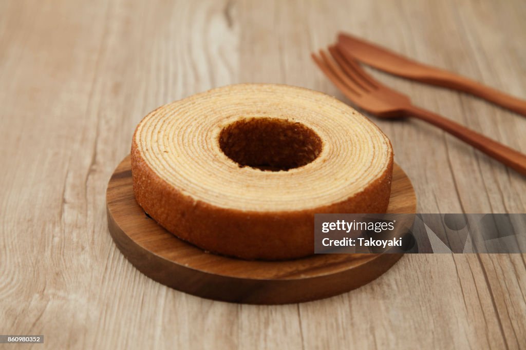 Baumkuchen deutsche Krapfen Kuchen auf Holzplatte Gabel Messer auf Tisch