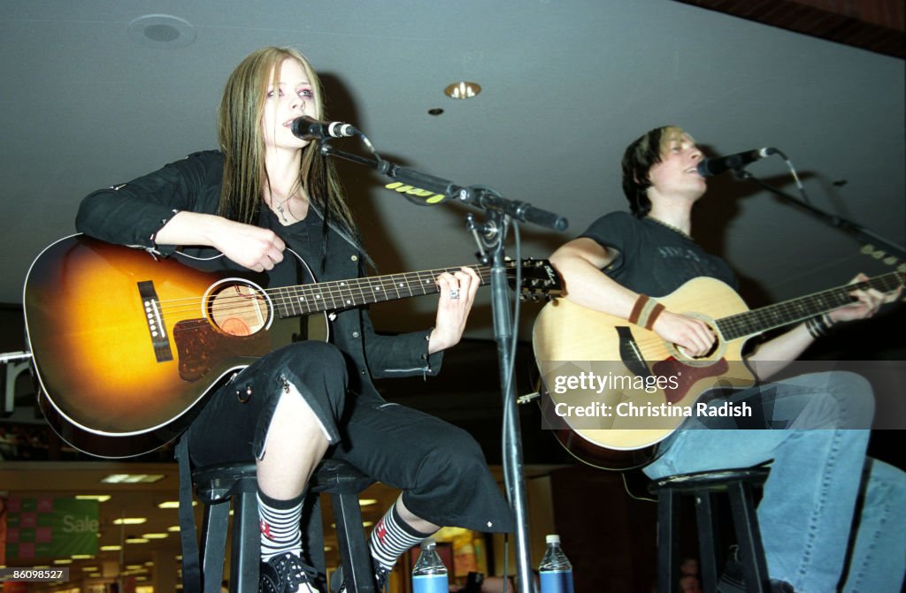 Avril Lavigne & Evan Taubenfeld performing during her mall tour to promote her upcoming album "Under My Skin" at a stop at the Glendale Galleria in Glendale, Calif. on April 12, 2004.,