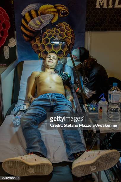 Tattooist at work on customers during the International Venice Festival Tattoo on October 13, 2017 in Venice, Italy.
