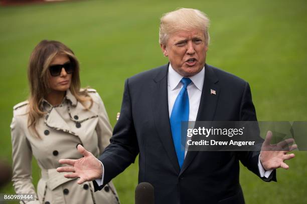 First Lady Melania Trump looks on as U.S. President Donald Trump takes questions from reporters, on their way to Marine One on the South Lawn of the...