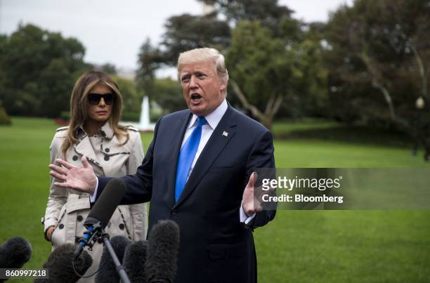 President Donald Trump, right, speaks to members of the media as First Lady Melania Trump stands before boarding Marine One on the South Lawn of the...