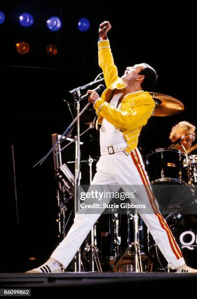 Freddie Mercury of Queen performs on stage with drummer Roger Taylor behind on the Magic Tour at Wembley Stadium, London, July 1986.