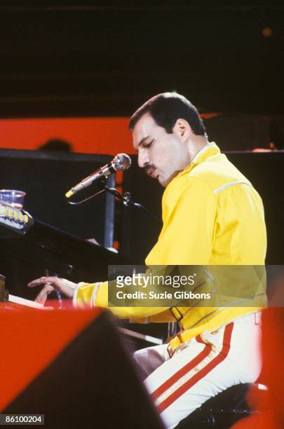 Freddie Mercury of Queen playing piano while performing on stage on the Magic Tour at Wembley Stadium, London, July 1986.