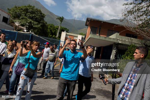 Henrique Capriles, opposition leader and former governor of the State of Miranda, right, uses a smartphone to live stream with periscope the changing...