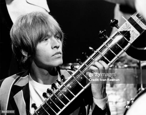 English musician Brian Jones of The Rolling Stones plays a sitar during a performance by the band on the set of the Associated Rediffusion Television...