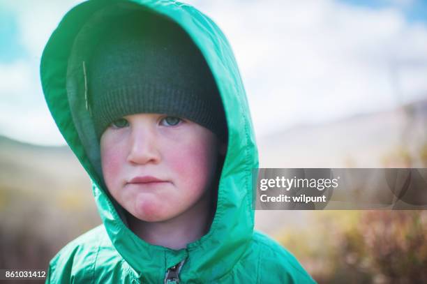 girl looking tired and sad outdoors - girl face hat raincoat stock pictures, royalty-free photos & images