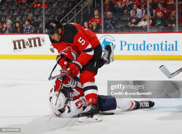 Dalton Prout of the New Jersey Devils take a first period penalty for interference against Tom Wilson of the Washington Capitals at the Prudential...