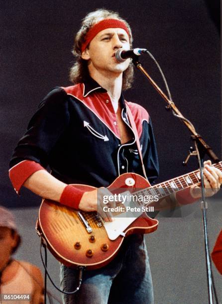 Photo of Mark KNOPFLER and LIVE AID and DIRE STRAITS, Mark Knopfler performing live onstage at Live Aid, playing Gibson Les Paul guitar, wearing...