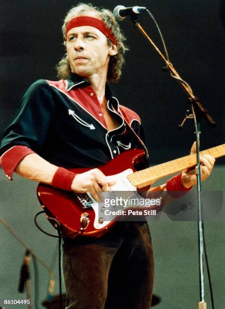 Photo of Mark KNOPFLER and LIVE AID and DIRE STRAITS, Mark Knopfler performing live onstage at Live Aid, playing Fender Stratocaster guitar, wearing...