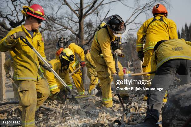 Firefighters search through the rubble of a home in the Fountaingrove neighborhood for a strongbox and a wedding ring on October 13, 2017 in Santa...