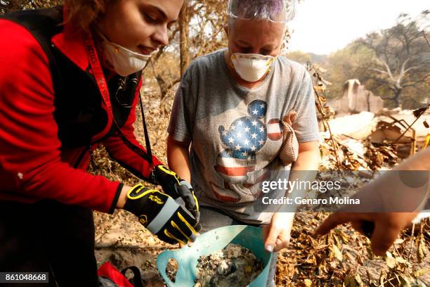 Lola Cornish center, and her daughter Kat Corazza look over recovered family jewels that survived the fire and destruction of Cornish's grandfather's...