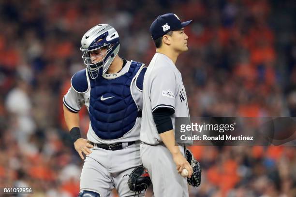 Masahiro Tanaka talks to Gary Sanchez of the New York Yankees after Sanchez was hit in the leg by a pitch in the third inning against the Houston...