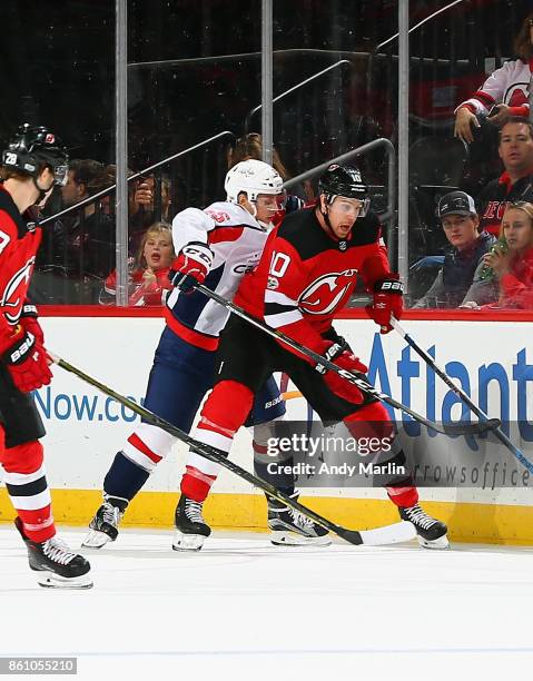 Jimmy Hayes of the New Jersey Devils and Aaron Ness of the Washington Capitals battle for position during the game at Prudential Center on October...