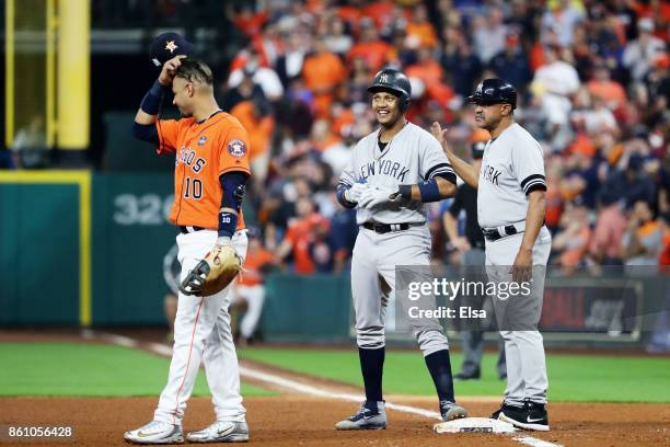 Starlin Castro of the New York Yankees celebrates with first base coach Tony Pena after his single in the fourth inning against the Houston Astros...