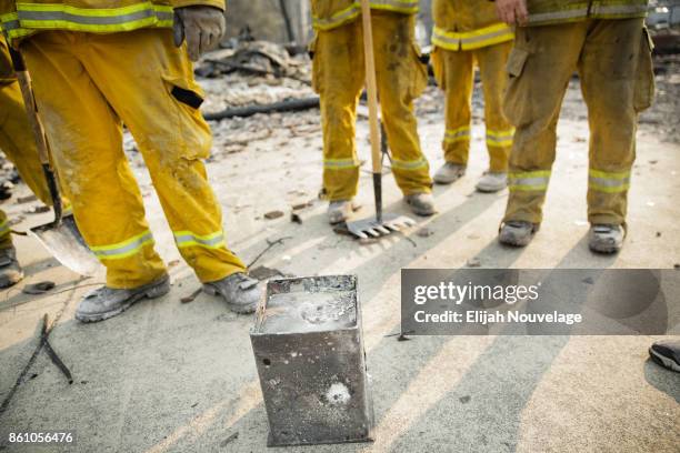 Firefighters stand around a safe recovered from the remains of a home in the Fountaingrove neighborhood on October 13, 2017 in Santa Rosa,...