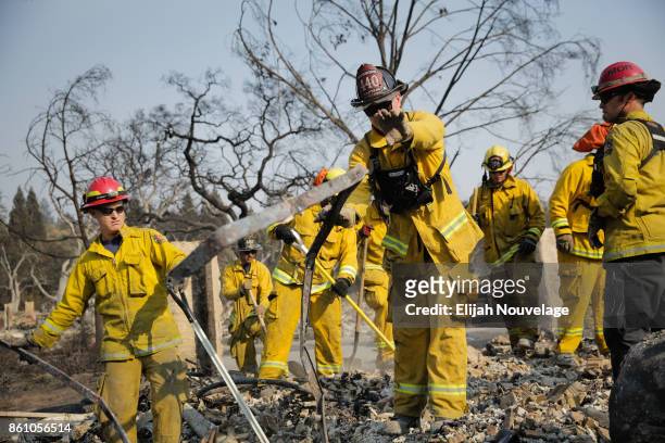 Firefighters search for a strongbox and a wedding ring through the remains of a home in the Fountaingrove neighborhood on October 13, 2017 in Santa...