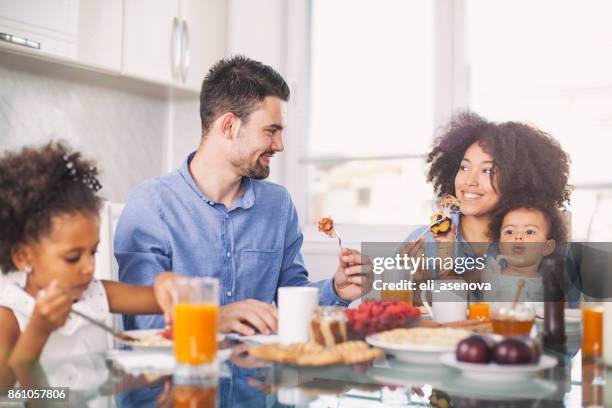 foto van een jong gelukkig gezin ontbijten - family breakfast stockfoto's en -beelden