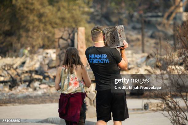 Julian and Lisa Corwin carry a neighbor's safe back to the remains of their home in the Fountaingrove neighborhood on October 13, 2017 in Santa Rosa,...