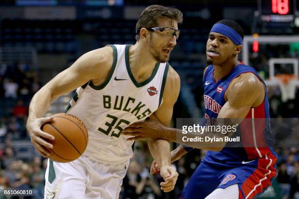 Mirza Teletovic of the Milwaukee Bucks dribbles the ball while being guarded by Tobias Harris of the Detroit Pistons in the second quarter during a...