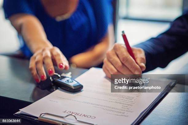 couple is buying new car and signing the contract - buying a car stock pictures, royalty-free photos & images
