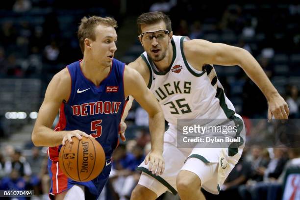 Luke Kennard of the Detroit Pistons dribbles the ball while being guarded by Mirza Teletovic of the Milwaukee Bucks in the fourth quarter during a...