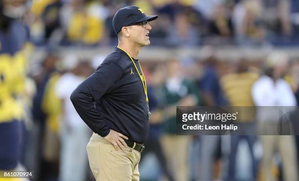 Michigan head football coach Jim Harbaugh watches the warms ups prior to the start of the game against the Michigan State Spartans at Michigan...