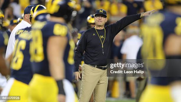 Michigan head football coach Jim Harbaugh watches the warms ups prior to the start of the game against the Michigan State Spartans at Michigan...