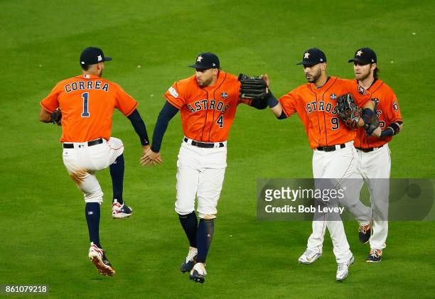 Carlos Correa and George Springer and Marwin Gonzalez of the Houston Astros celebrate their 2 to 1 win over the New York Yankees during game one of...