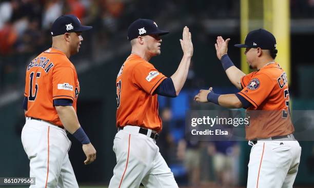 Ken Giles of the Houston Astros celebrates with teammates Carlos Beltran and Juan Centeno after their 2 to 1 win over the New York Yankees during...