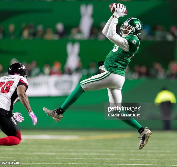 Duron Carter of the Saskatchewan Roughriders takes a peek at Corey Tindal of the Ottawa Redblacks while making a catch in the first half of the game...