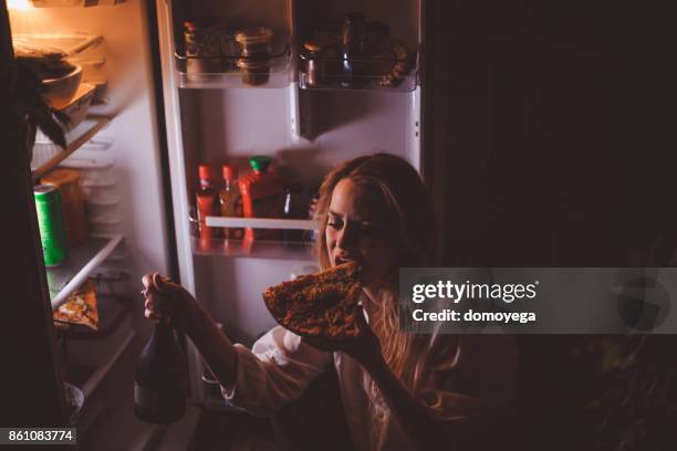 young woman drinking and eating late night - eating disorder stock pictures, royalty-free photos & images