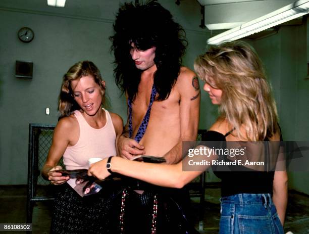 Tommy Lee of Motley Crue looking at photographs with wife Heather Locklear .