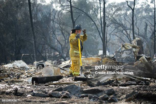 Firefighter pauses for a moment while looking through the rubble of a home in the Fountaingrove neighborhood on October 13, 2017 in Santa Rosa,...