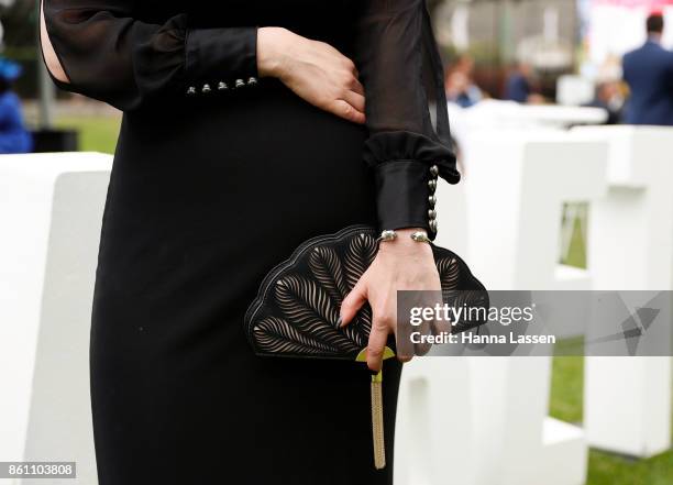 Guest wearing a Kate Spade clutch, Alexander McQueen bangle and House of K'dor ring at TAB Everest Day at Royal Randwick Racecourse on October 14,...