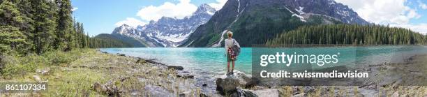 panoramic view of girl looking out spectacular mountain lake landscape - jasper stock pictures, royalty-free photos & images