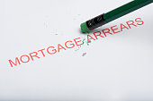 Pencil Erasing the Word 'Mortgage Arrears' on Paper