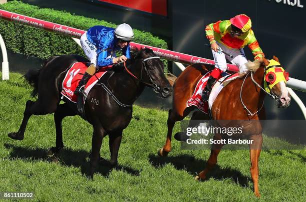 Jockey Michael Walker riding Mighty Boss celebrates as he wins race 8 the Ladbrokes Caulfield Guineas as jockey Damian Lane riding Kementari runs...