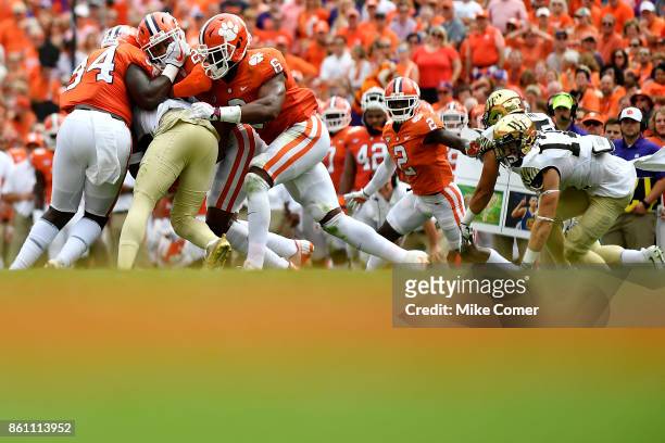 Safety Van Smith, linebacker Dorian O'Daniel, and linebacker Kendall Joseph of the Clemson Tigers tackle a Wake Forest Demon Deacon during the...