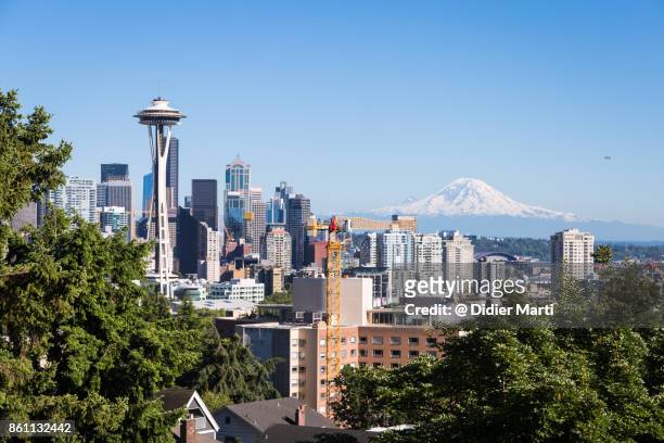 famous view of seattle skyline with the space needle and mt rainier - seattle stock-fotos und bilder