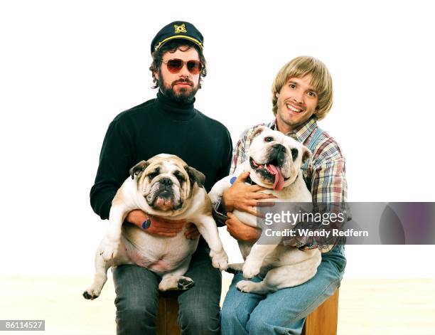 Photo of Bret McKENZIE and FLIGHT OF THE CONCHORDS and Jemaine CLEMENT; Posed studio group portrait of Jemaine Clement and Bret McKenzie, pet, dog