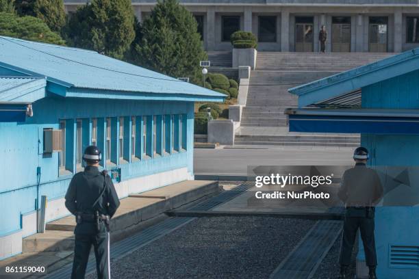 South Korean soldier stand guard, facing a North Korean soldier, in the border village of Panmunjom between South and North Korea at the...