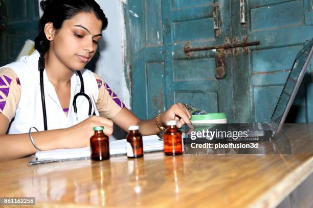 jovem médico trabalhando no laptop - países-em-desenvolvimento - fotografias e filmes do acervo
