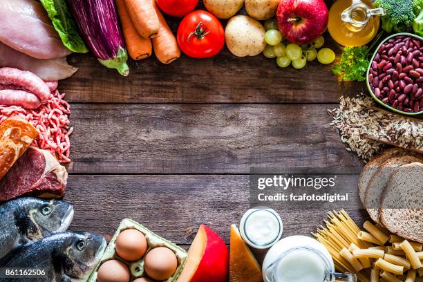 different types of food making a border on rustic wooden table - food table edge stock pictures, royalty-free photos & images