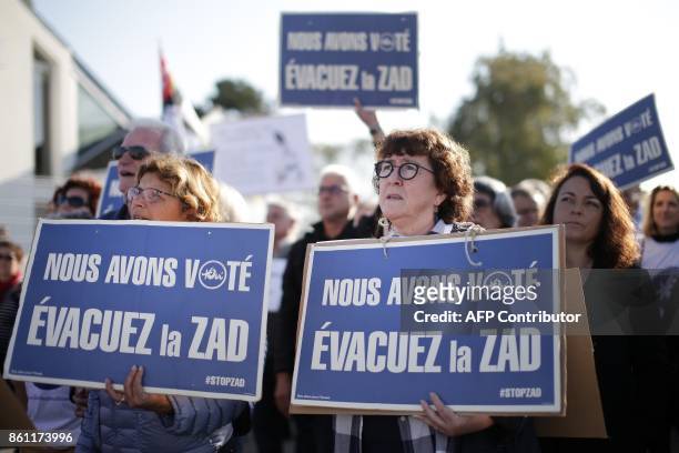 People hold placards reading "We have voted. Clear the ZAD" during a demonstration by supporters of the international airport project of...