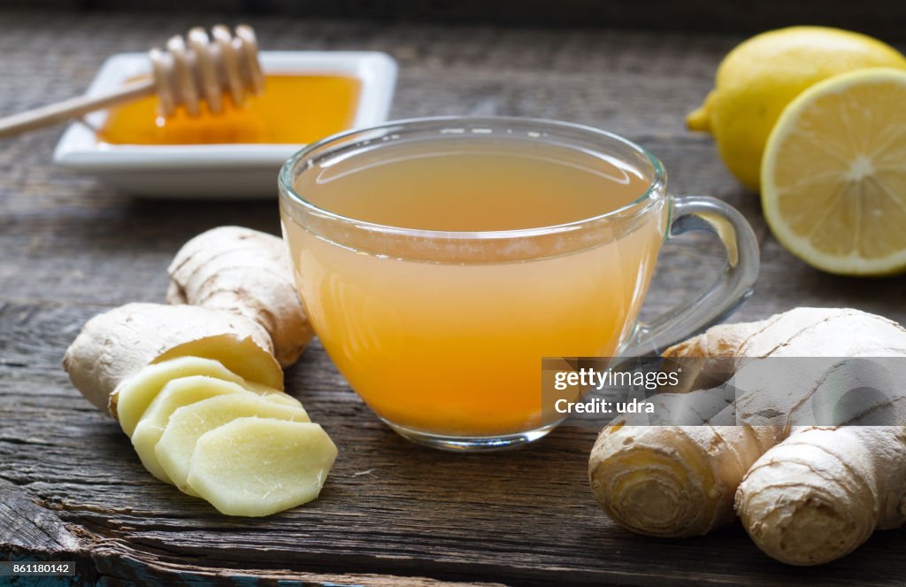 Ginger homemade tea infusion on wooden board with lemon