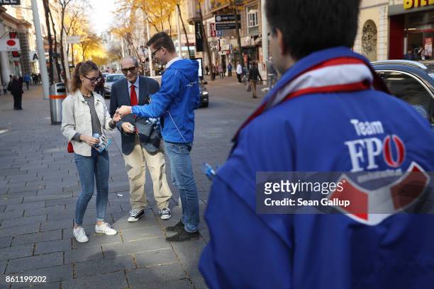 Election campaign workers of the right-wing Austria Freedom Party distribute pamphlets and party mechandise to passers-by on October 14, 2017 in...