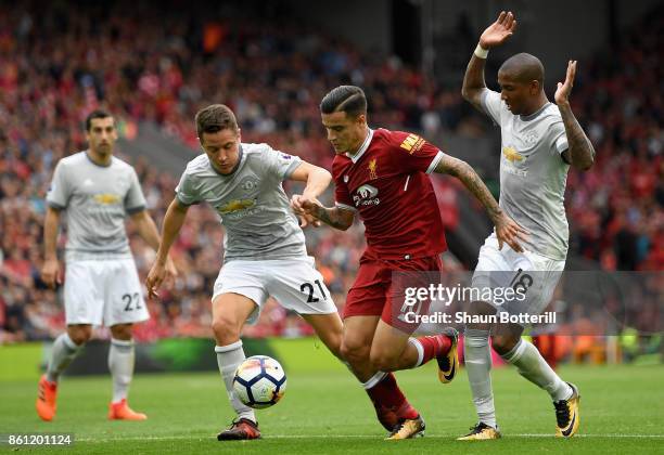 Philippe Coutinho of Liverpool battles for possession with Ander Herrera and Ashley Young of Manchester United during the Premier League match...