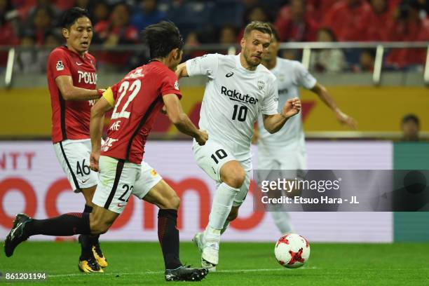 Lukas Podolski of Vissel Kobe controls the ball under pressure of Ryota Moriwaki and Yuki Abe of Urawa Red Diamonds during the J.League J1 match...